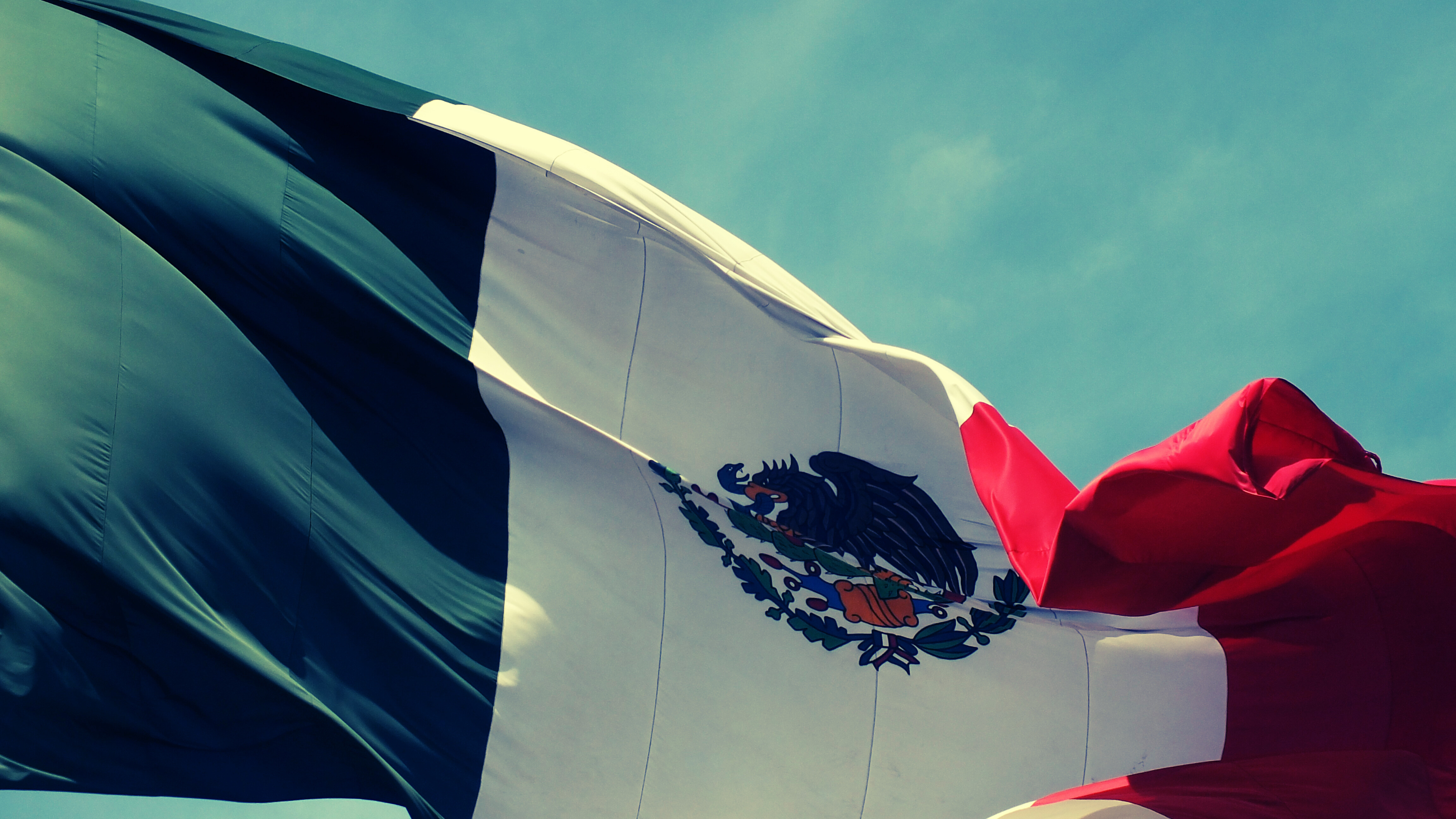 Fotografía de la bandera mexicana ondeando en el aire (Crédito Pawiis09 de pixabay vía Canva Pro) (1)